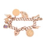 A 9ct gold charm bracelet featuring nine charms including Lady Liberty, a Morris Minor car, a retrac