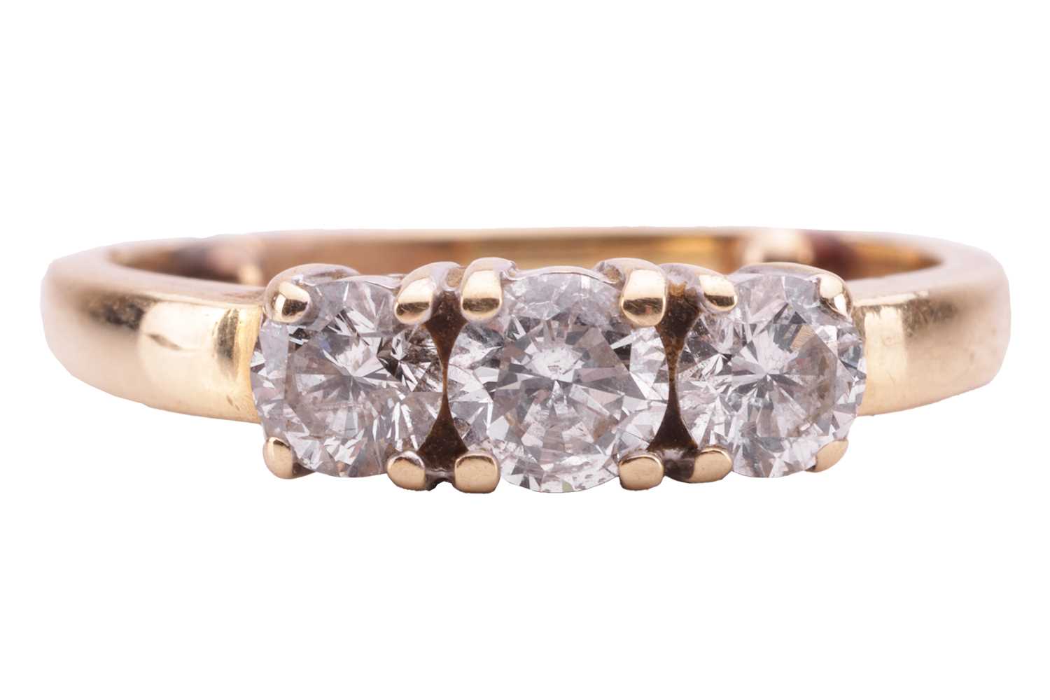 A diamond three-stone ring, claw-set with three round brilliant diamonds, the central stone measurin