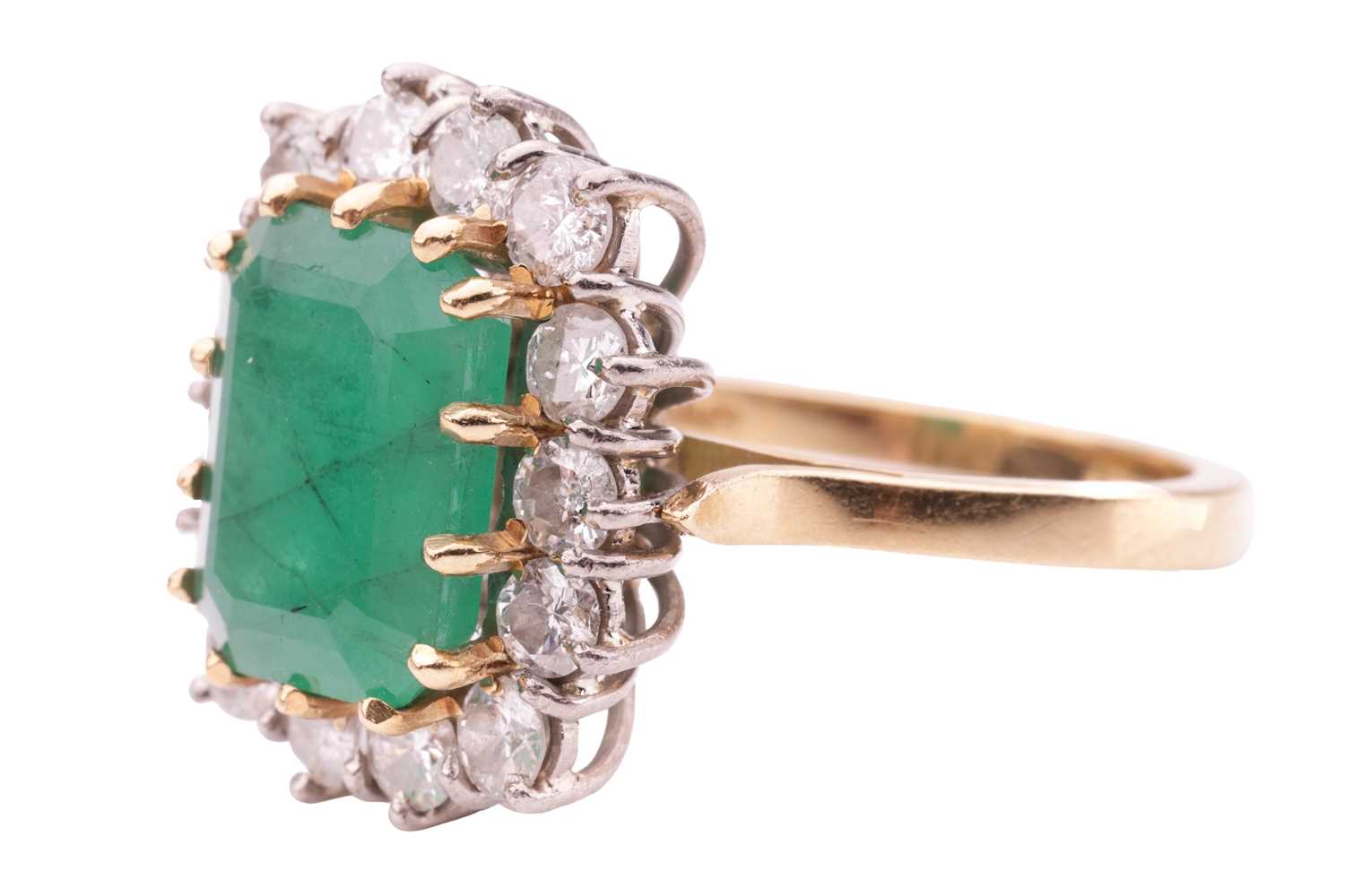 An emerald and diamond cluster ring, set with an emerald measuring 10.8 x 8.2 x 5.2mm, encircled by  - Image 2 of 4