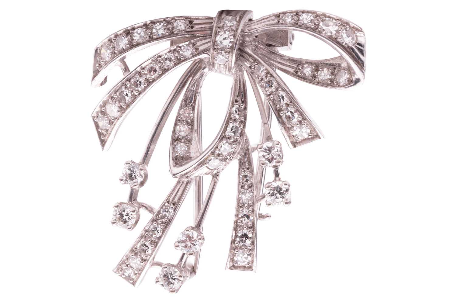 A diamond-set bow dress clip/brooch, the central bow and ribbons claw-set with single-cut diamonds, 