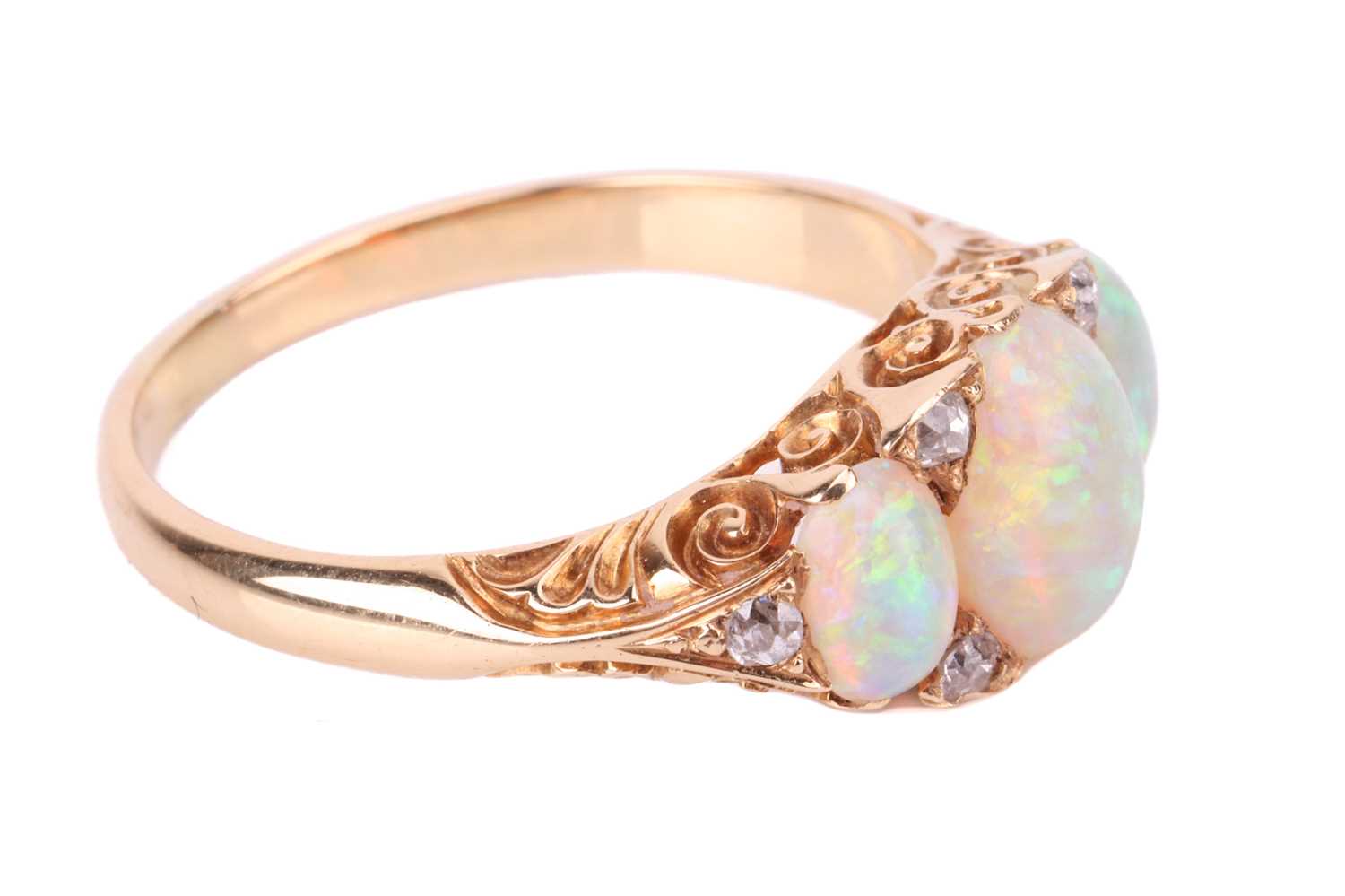An opal and diamond half-hoop ring, featuring three graduated oval cabochons, displaying spectral pl - Image 2 of 4