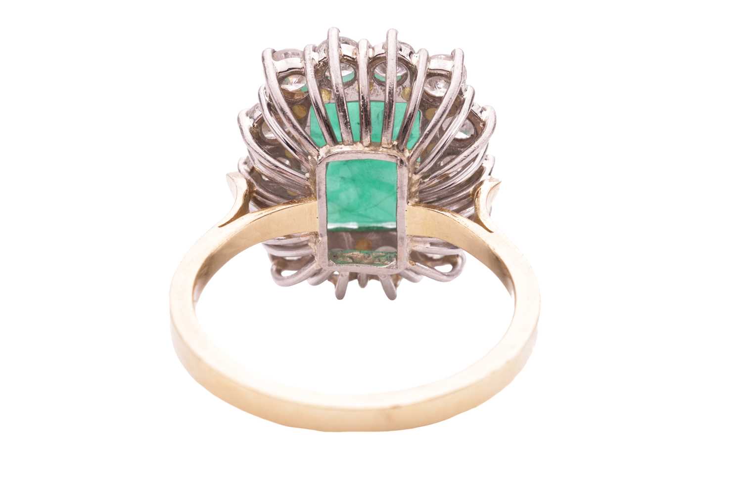 An emerald and diamond cluster ring, set with an emerald measuring 10.8 x 8.2 x 5.2mm, encircled by  - Image 3 of 4