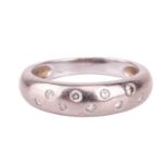 A diamond-set band ring. Stamped 750. The D-shaped band is set with 9 round brilliant cut diamonds, 