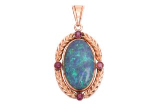 An opal and ruby pendant, featuring a large oval cabochon of a precious opal of 2.4 x 1.5 cm,