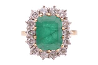An emerald and diamond cluster ring, set with an emerald measuring 10.8 x 8.2 x 5.2mm, encircled by 