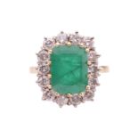 An emerald and diamond cluster ring, set with an emerald measuring 10.8 x 8.2 x 5.2mm, encircled by 