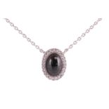 A jet and diamond halo pendant, set in 18ct white gold, featuring an oval jet cabochon measuring app