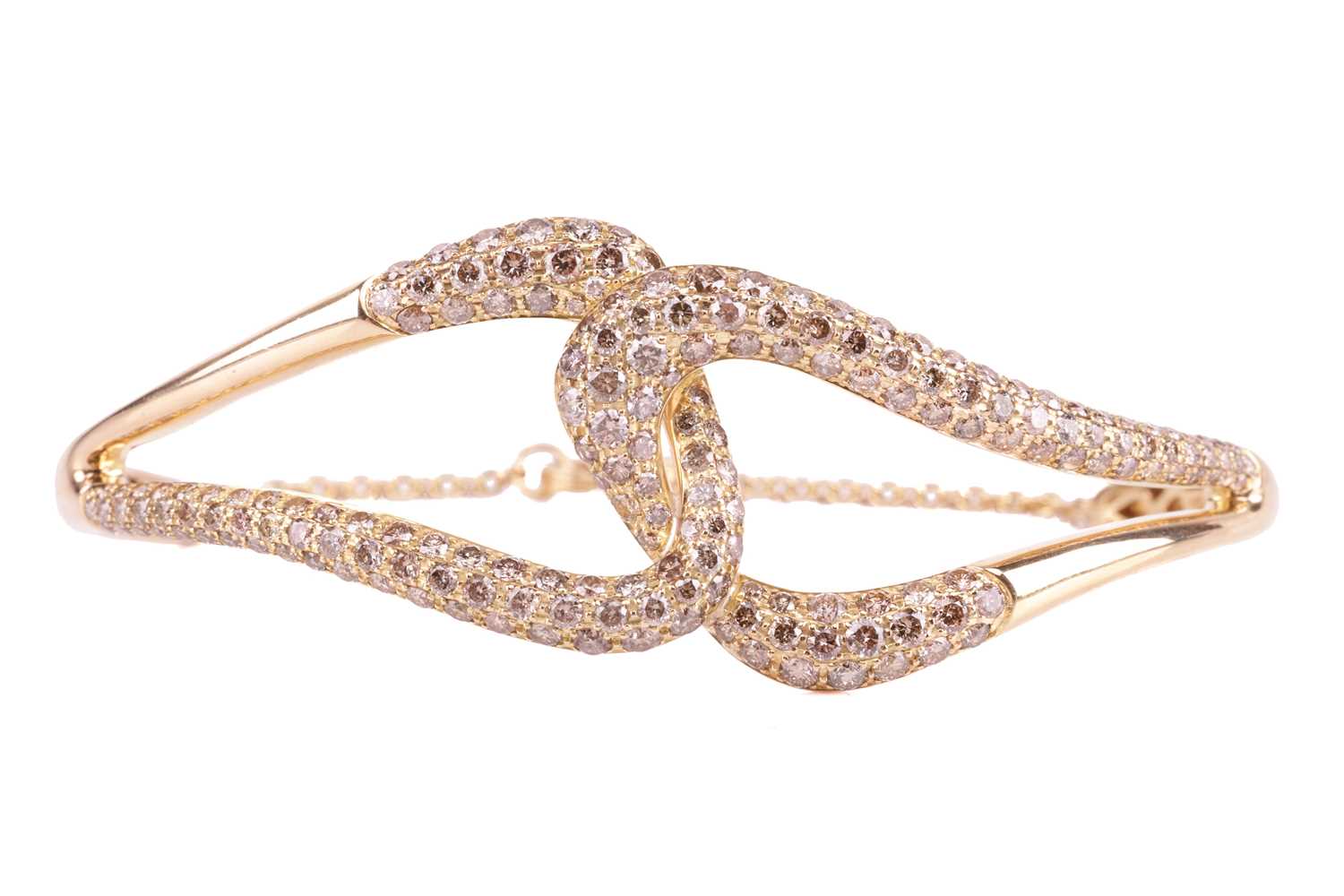 A diamond bangle, in a linked cross-over design set throughout with round brilliant cut champagne di