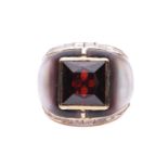 A gem-set cocktail ring, centred with a square scissors-cut garnet in collet, shoulders inlaid with 