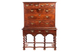 A 17th-century and later figured walnut chest on stand, the upper section with quarter veneered