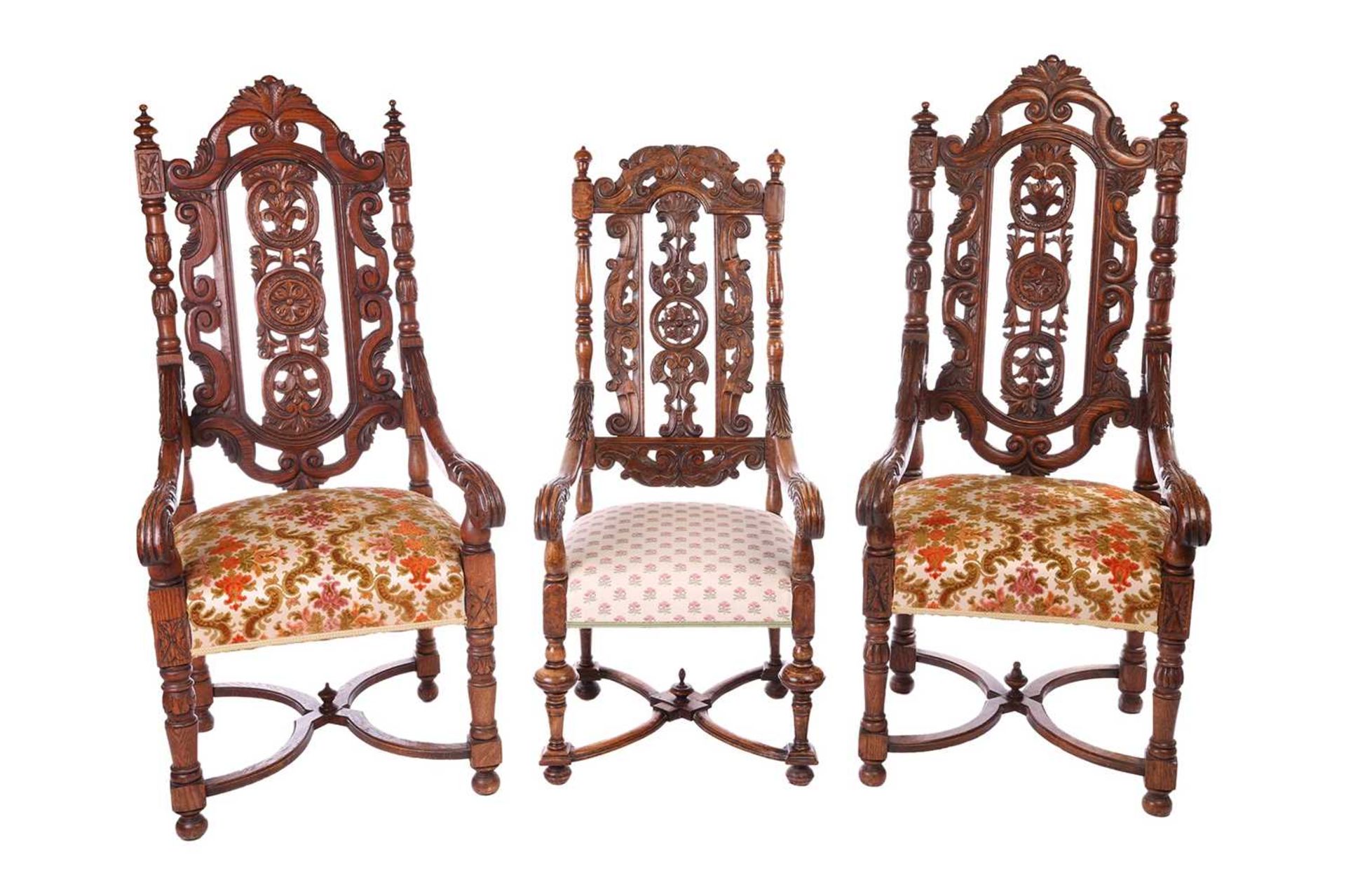 A near pair of Victorian carved oak open armchairs, in the Carolean style, with open S-Scroll, roset