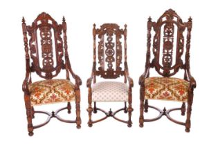 A near pair of Victorian carved oak open armchairs, in the Carolean style, with open S-Scroll,