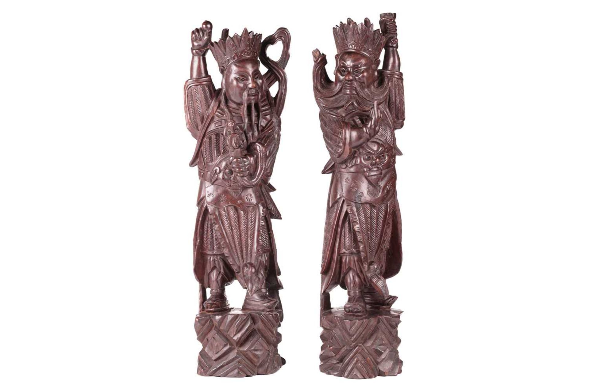 A pair of Chinese carved cherry wood figures of warriors one possibly Xianwu both with inset glass b