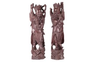 A pair of Chinese carved cherry wood figures of warriors one possibly Xianwu both with inset glass