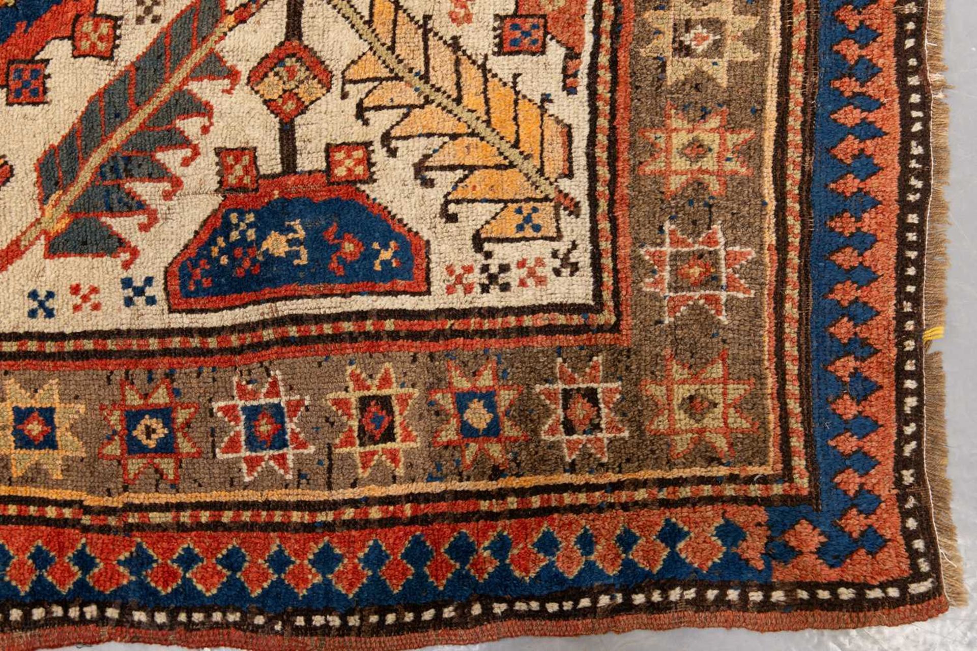 A Kazak Rug, the serrated leaf and medallion design on an ivory field, within a star and serrated bo - Image 6 of 6