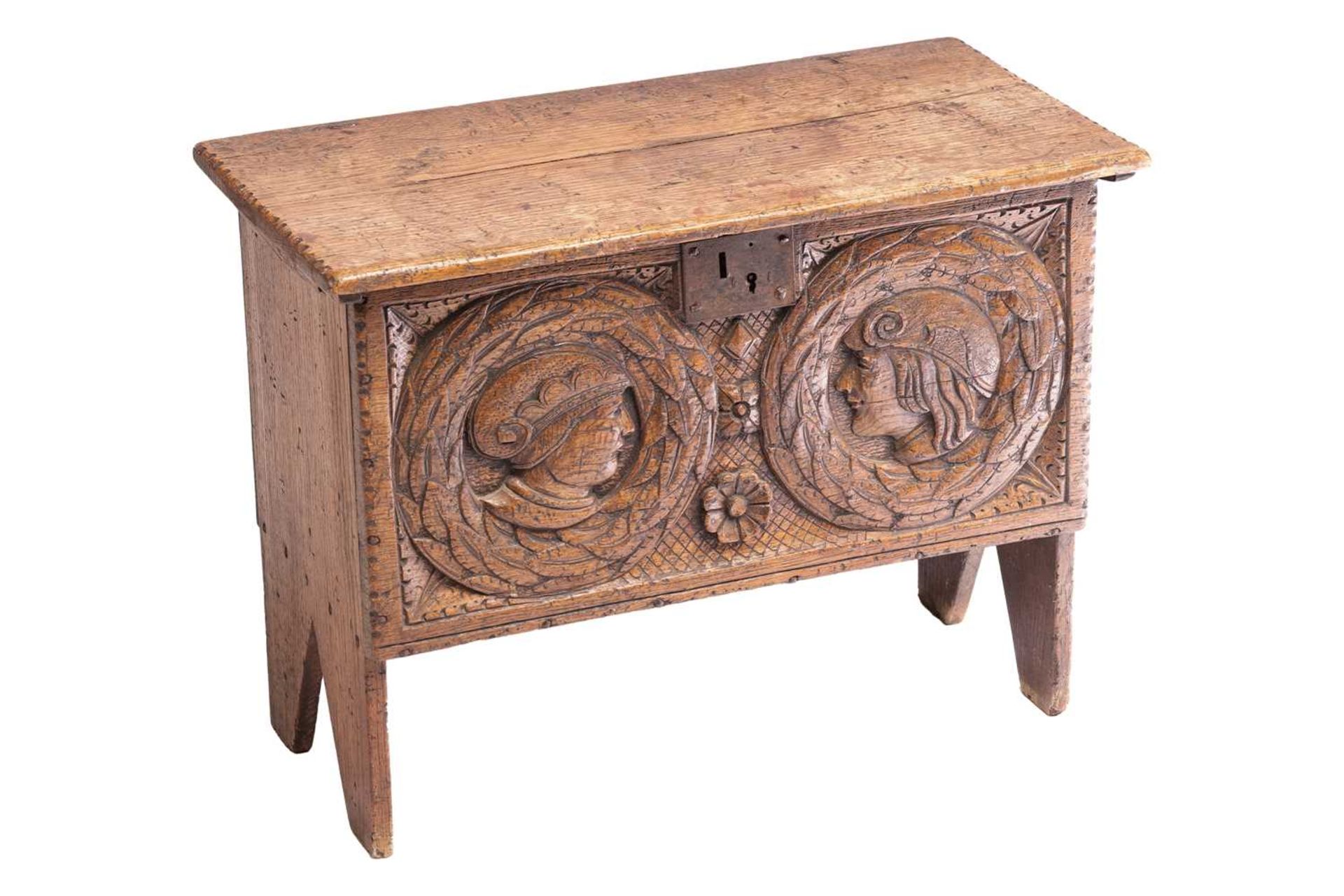A small 17th-century style oak six-plank coffer, the frieze carved with Romanesque portrait roundels