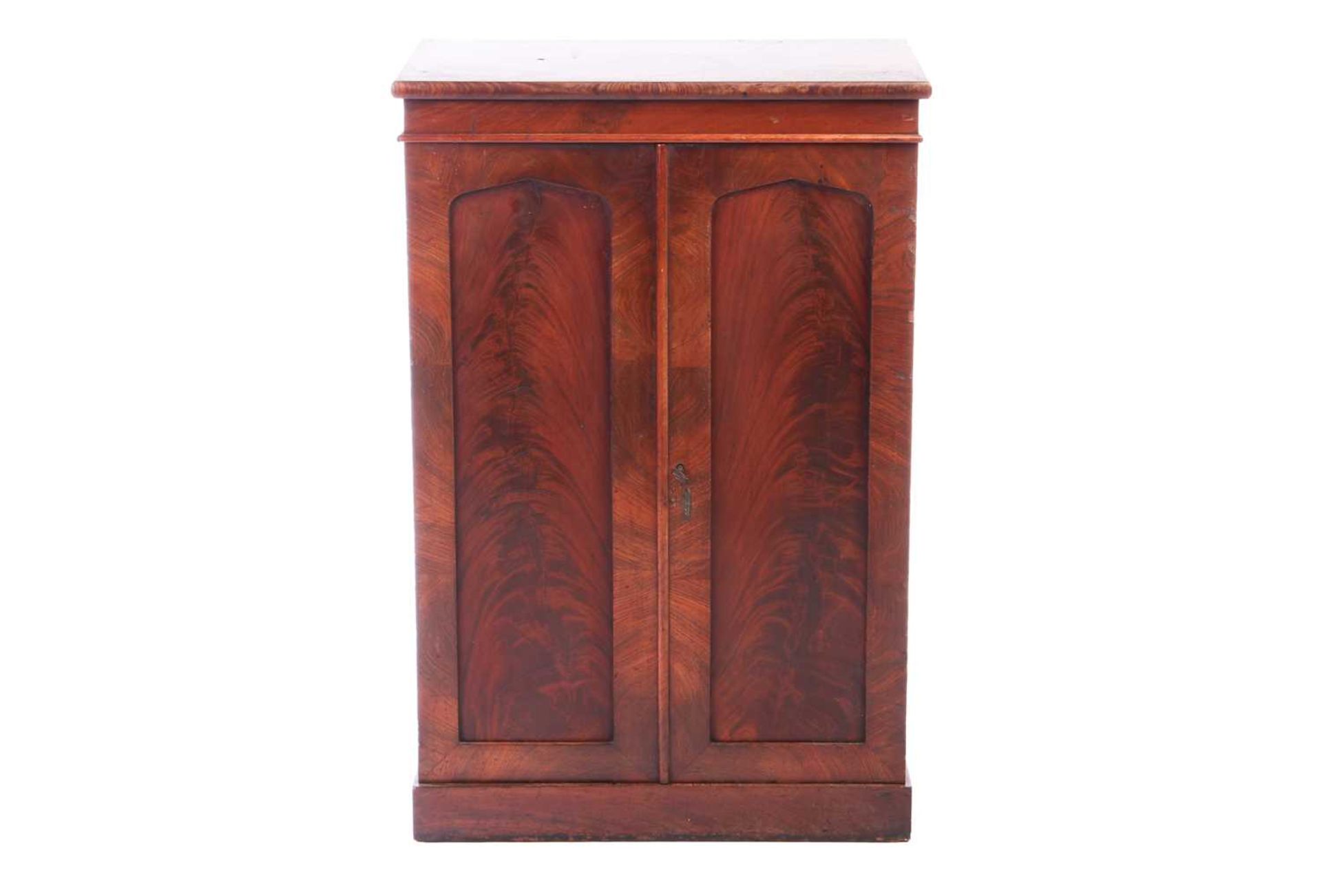 A mid-Victorian flame mahogany collector's cabinet, the pair of arched panelled doors enclosing eigh