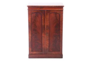 A mid-Victorian flame mahogany collector's cabinet, the pair of arched panelled doors enclosing