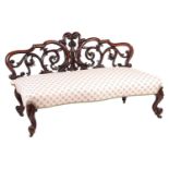 An unusual Victorian rosewood window seat/Couch, with an openwork back carved with scrolls over a st