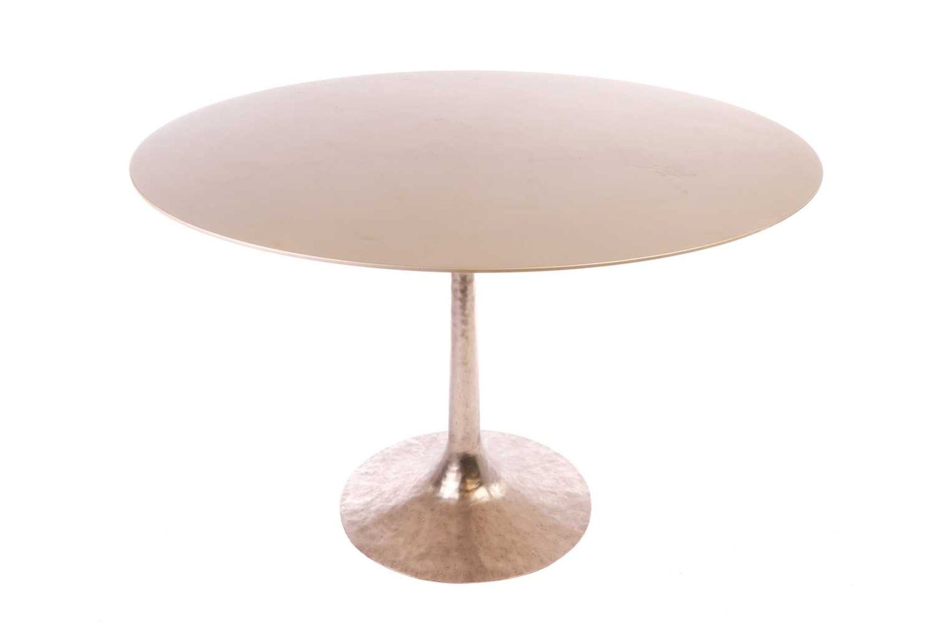 A Julian Chichester 'Dakota' Dining Table, the gold effect finish circular top on a hand-hammered ch