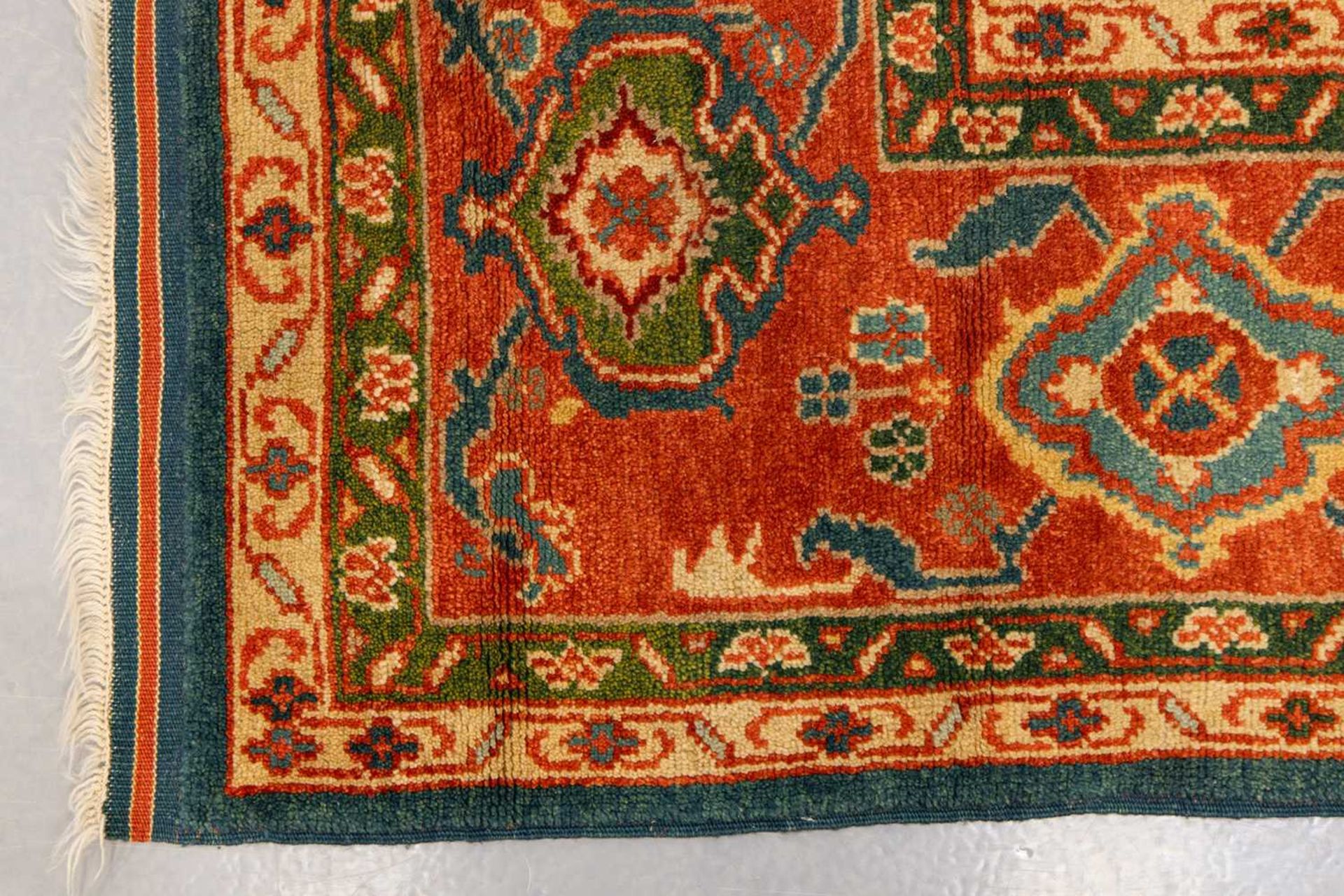 A large Ushak Carpet, the red palmette and leaf design on a blue/green field, within a light red bor - Image 6 of 23