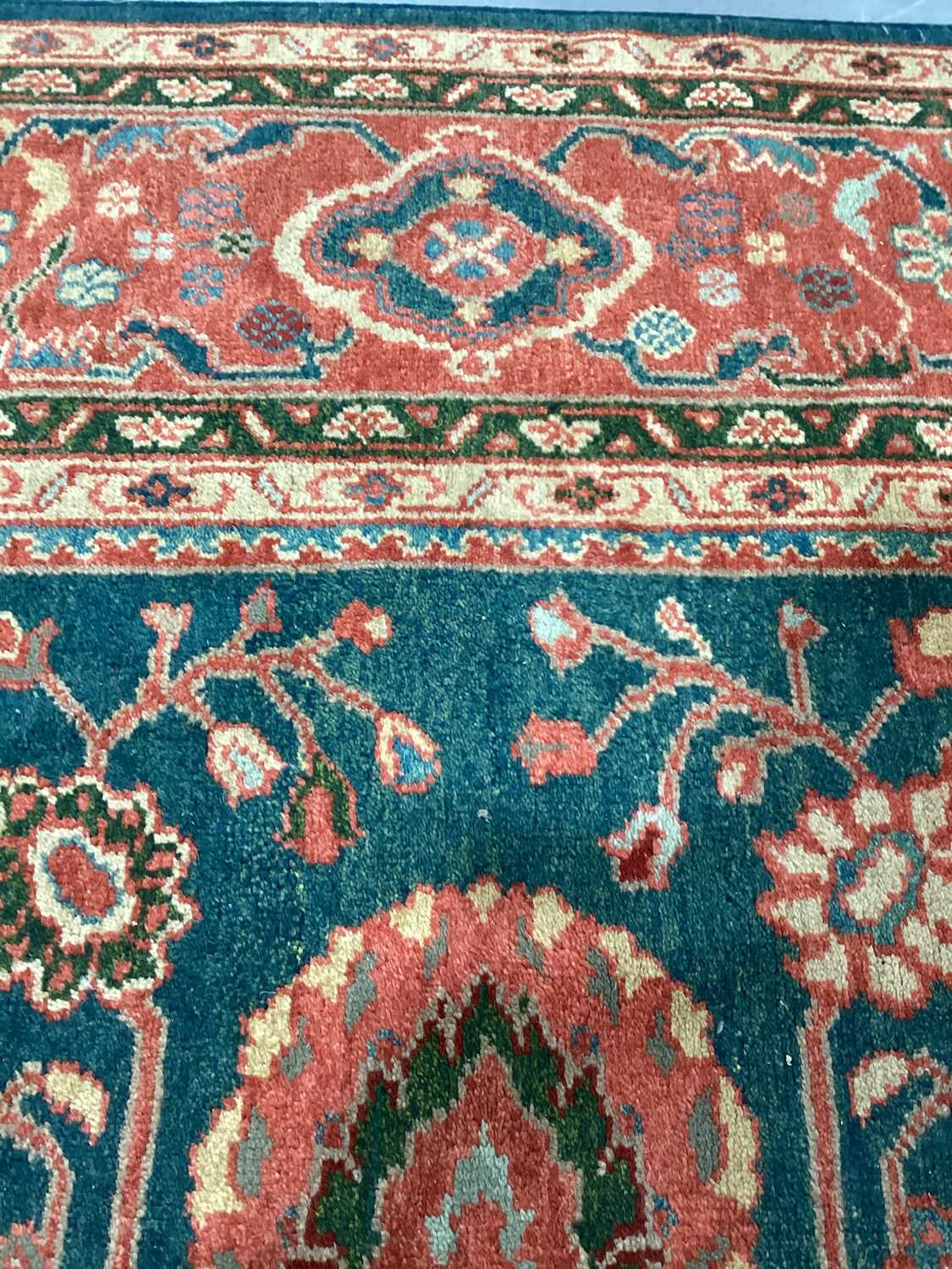 A large Ushak Carpet, the red palmette and leaf design on a blue/green field, within a light red bor - Image 9 of 23