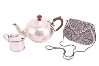 A silver teapot, circular panelled form with fruitwood handle and knop finial to domed cover.