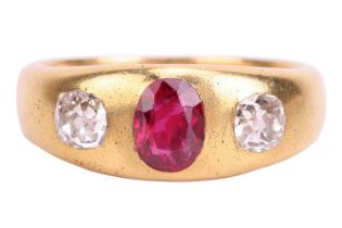 A ruby and diamond three-stone gypsy ring, centred with an oval-cut ruby in deep pinkish-red colour,