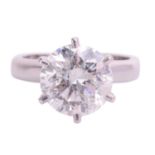 A diamond solitaire ring in platinum, claw-set with a round brilliant diamond approximately measurin