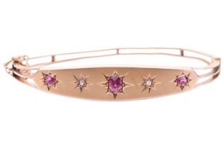 A late Victorian pink sapphire and diamond hinged bangle, front panel star-set with three