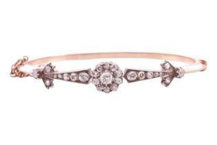 A late Victorian diamond hinged bangle, featuring a central cluster of old cut diamonds, between a