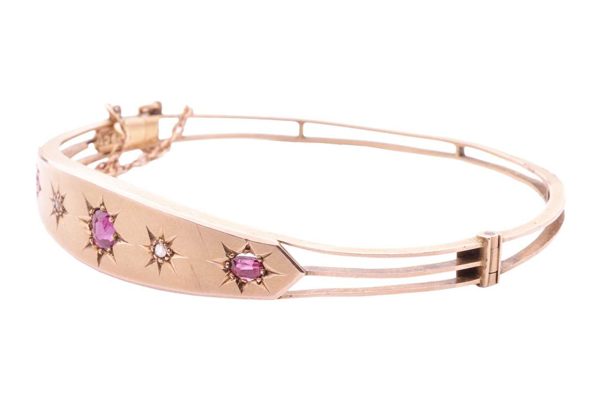 A late Victorian pink sapphire and diamond hinged bangle, front panel star-set with three graduated  - Image 2 of 4