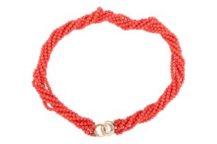 A coral torsade necklace, comprising seven strands of coral beads, completed with a clasp of annular