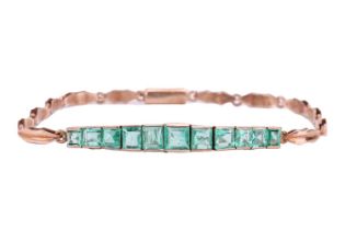 An Art Deco emerald line bracelet, set with a row of eleven graduated calibré cut emeralds, in