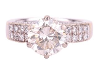 A diamond solitaire ring with diamond set shoulders, featuring a 3.02ct round brilliant cut