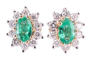 A pair of emerald and diamond cluster earrings, the central oval-cut emeralds measuring