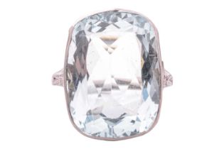 A large aquamarine dress ring, collet-set with a cushion-cut aquamarine of 19.0 x 14.0 x 7.5 mm,