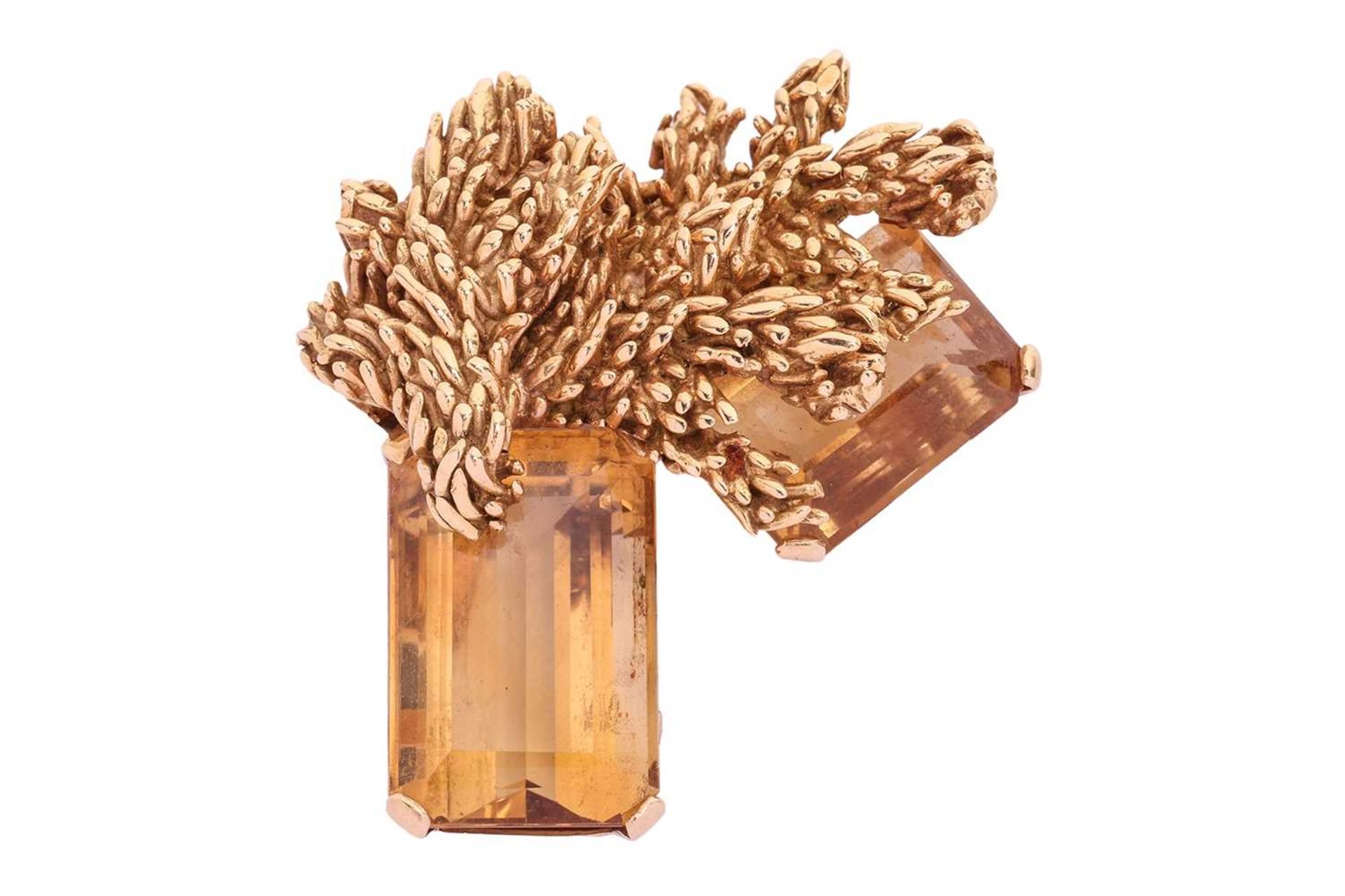 A large Modernist citrine brooch, of naturalistic design, cast surmounts superimposed upon two emera