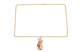 A diamond-set kinetic pig pendant on chain, designed as a sitting pig with diamond-set eyes and
