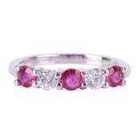 A pink sapphire and diamond five-stone ring, featuring two round brilliant diamonds set between thre