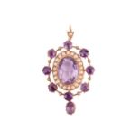 An Edwardian amethyst and seed pearl pendant, the central oval amethyst measuring approximately 13.5