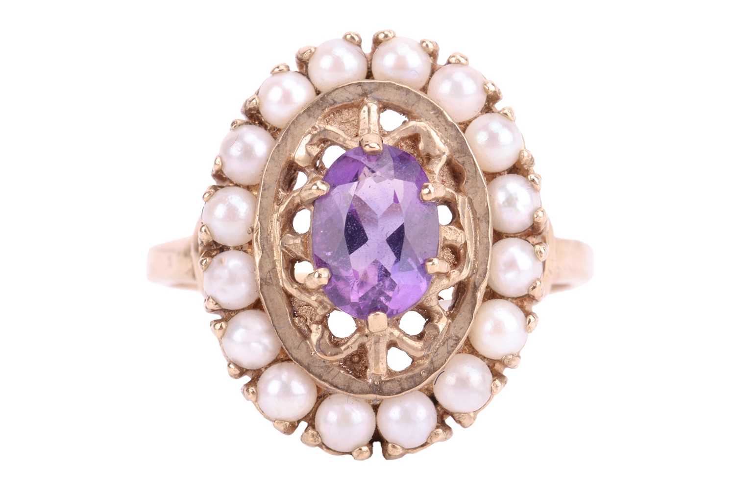 An amethyst and seed pearl cluster ring, featuring an oval cut amethyst measuring 7 x 5 x 3.5mm, in 