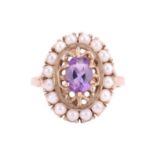 An amethyst and seed pearl cluster ring, featuring an oval cut amethyst measuring 7 x 5 x 3.5mm, in 