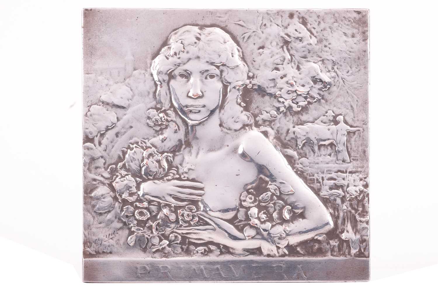 A white metal plaque titled 'Primavera' by René Grégoire, low-relief depicting a lady amidst foliage