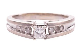 A single-stone diamond ring; the princess-cut diamond in raised four claw mount with bifurcated