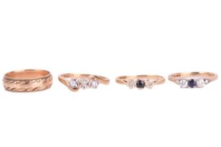 A collection of four rings; comprising a diamond three-stone ring set with round brilliant cut