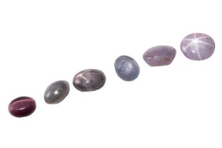 Five loose oval cabochons with asterism optical effects, and a fibre optic glass; including a 2.