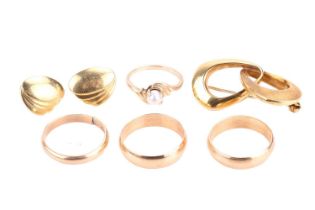 A small collection of jewellery including three court-shaped yellow metal wedding bands, two stamped