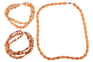 Two amber bead necklaces and another; to include a three-strand clarified amber bead necklace of