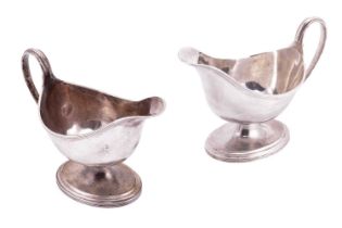 Elkington &amp; Co.:- a pair of silver sauceboats of oval form with reeded rim, loop handle and foot